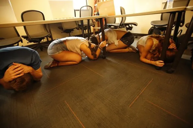 USC Cinema students take cover under their desks during an earthquake drill on October 15, 2015 in Los Angeles California. Students joined 21.5 million people worldwide who took part in safety drills and aftermath and recovery exercises in observance of the eighth annual Great ShakeOut. (Photo by Al Seib/Los Angeles Times via Getty Images)