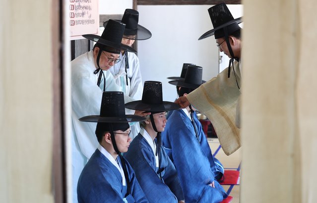 Students from abroad have “gat”, a traditional Korean hat, put on during the traditional Korean coming-of-age ceremony at Yeungnam University in Gyeongsan, South Korea, 14 May 2025. (Photo by Yonhap/EPA/EFE)