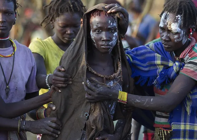 A Pokot girl, covered in animal skins, walks to a place where she will rest after being circumcised in a tribal ritual in a village about 80 kilometres from the town of Marigat in Baringo County, October 16, 2014. (Photo by Siegfried Modola/Reuters)