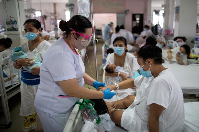 Filipino nurse Marciana Erispe tends to a mother inside the maternity ward of the government-run Dr. Jose Fabella Memorial Hospital in Manila, Philippines, September 18, 2020. As the Philippines grapples with rising coronavirus infections, new mothers and medical staff at one of the world's busiest maternity hospitals face heightened anxiety during the pandemic. In the Dr Jose Fabella Memorial Hospital in Manila overcrowding has been a problem for years, with new mothers often having to share beds due to high admissions. (Photo by Eloisa Lopez/Reuters)