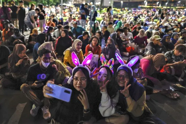 People take a selfie as they gather for the New Year's Eve celebrations at the main roundabout in Jakarta, Indonesia on December 31, 2022. Thousands of people gathered for New Year's Eve celebrations as the country officially lifted Covid-19 related restrictions. (Photo by Mast Irham/EPA/EFE)