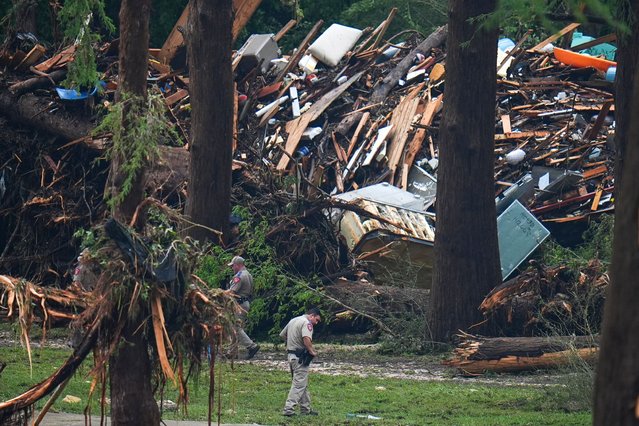 Officials comb through the banks of the Guadalupe River after a flash flood swept through the area Saturday, July 5, 2025, in Hunt, Texas. (Photo by Julio Cortez/AP Photo)