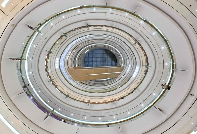 A man checks his phone as he visits a shopping mall in Beijing on July 1, 2025. (Photo by Adek Berry/AFP Photo)