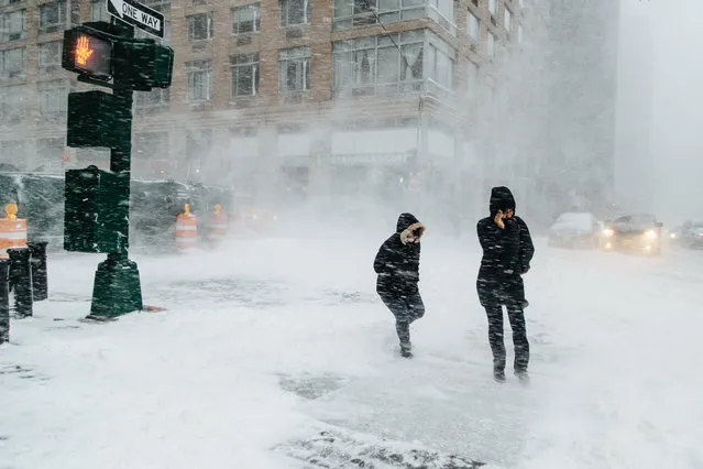 People walk in the street in New York, New York, USA, 04 January 2018. A Nor'easter snow storm is expected to bring up to 8 inches (20 cm) of snow in the New York area. (Photo by Alba Vigaray/EPA/EFE)