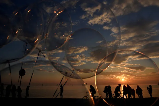 People are seen through balloons as they make their way at the seaside promenade of the northern port city of Thessaloniki, Greece December 27, 2017. (Photo by Alexandros Avramidis/Reuters)