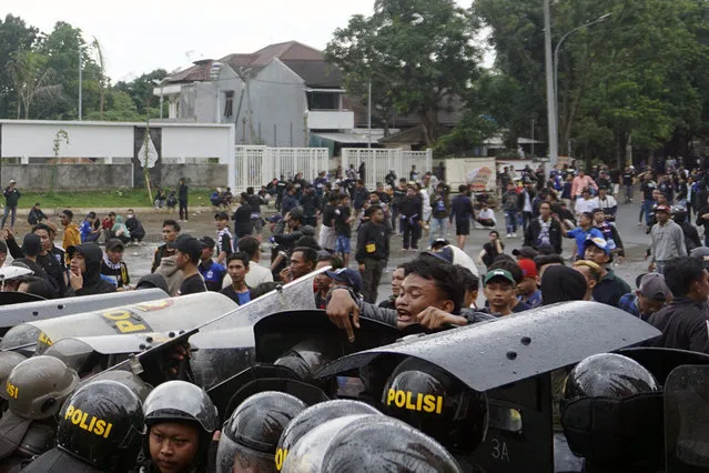 Riot police officers block soccer supporters outside Jatidiri Stadium in Semarang, Central Java, Indonesia, Friday, February 17, 2023. Indonesian police fired tear gas to disperse fans who were trying to force their way into a match that was held without spectators, months after the use of tear gas in another stadium in East Java caused one of the world's worst sporting disasters. (Photo by Adhik Kurniawan/AP Photo)