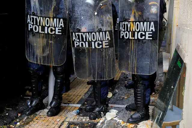 Riot police officers stand guard as leftovers of broken eggs thrown by demonstrators are seen on their shields and on the ground, during a protest outside a notary's office to prevent an e-auction of repossessed properties in Athens, Greece, March 21, 2018. (Photo by Alkis Konstantinidis/Reuters)
