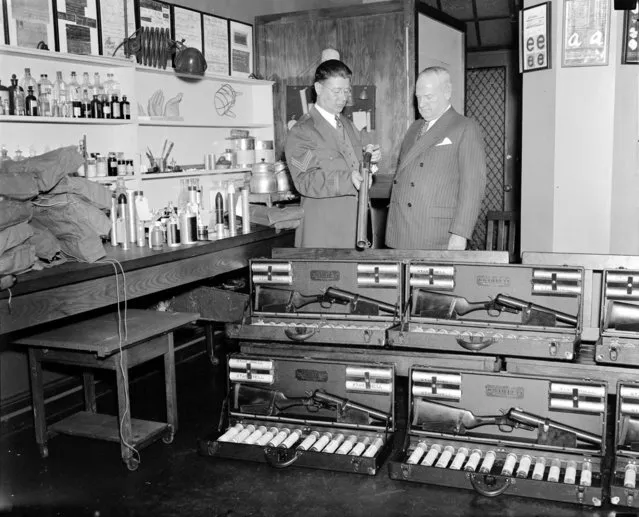Inspecting new riot guns at police headquarters, 1936. (Photo by Leslie Jones)