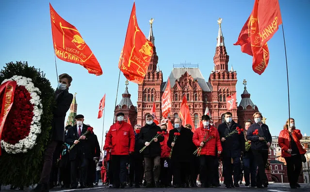 Russian Communist supporters march towards the Mausoleum of Vladimir Lenin to lay flowers on the 102nd anniversary of the Komsomol on Red Square in Moscow on October 28, 2020. Komsomol, The All-Union Leninist Young Communist League, was a political youth organisation in the Soviet Union, the youth division of the Soviet Communist Party,  established in 1918 and died shortly after the collapse of the Soviet Empire in 1991. (Photo by Alexander Nemenov/AFP Photo)