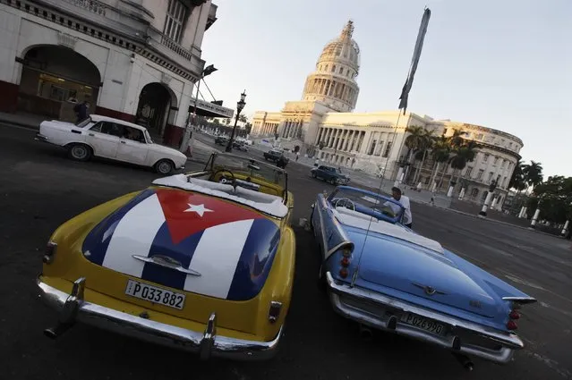 A car with a Cuban flag is parked near Cuban Capitol in Havana December 18, 2014. Cuban President Raul Castro hailed a landmark exchange of prisoners with the United States on Wednesday and praised U.S. President Barack Obama as the two countries agreed to normalize relations after more than five decades of hostility. (Photo by Enrique De La Osa/Reuters)