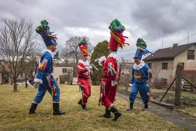 People dressed in traditional Czech folklore costumes dance as they parade through the village of Blatno, part of the Hlinsko town near the east Bohemian city of Pardubice, Czech Republic, during the traditional Masopust carnival celebration on February 20, 2022. The festival marks the beginning of Lent and is the equivalent to the Carnival, as “masopust” refers to “giving up meat”. (Photo by Michal Cizek/AFP Photo)