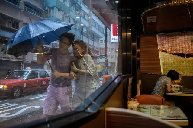 A couple walks in the heavy rain as Typhoon Haima makes landfall in Hong Kong, October 21, 2016. (Photo by Anthony Wallace/AFP Photo)