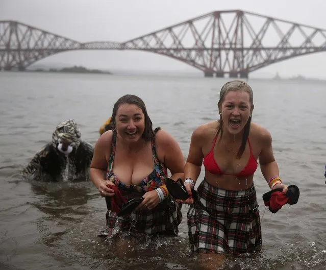 Swimmers in fancy dress rush out of the water as they participate in the New Year's Day Loony Dook swim at South Queensferry, Scotland January 1, 2015. (Photo by Russell Cheyne/Reuters)