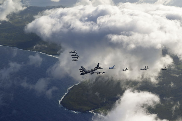 A US Air Force B-52 bomber flanked by fighter jets over Tinian Island on February 6, 2024. Participants exercise interoperability during Cope North 24 through agile combat employment and integrated generation of Air Power from dispersed locations across the Indo-Pacific. (Photo by U.S. Air Force photo by Staff Sgt. Gerald R. Willis)