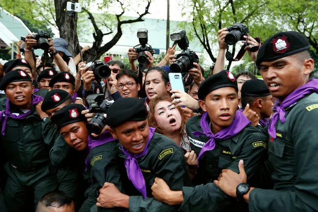 Photographers and journalists are blocked by policemen as they arrest protesters during a rally calling for general election to mark the fourth anniversary of military coup at Ratchadamnoen Avenue, near Government House in Bangkok, Thailand, 22 May 2018. Several demonstrators including the protest leaders were arrested in the pro-democracy rally to mark the fourth anniversary of military coup calling the junta government to hold an election in 2018 instead of February 2019 as promised by Thai prime minister. (Photo by Rungroj Yongrit/EPA/EFE)