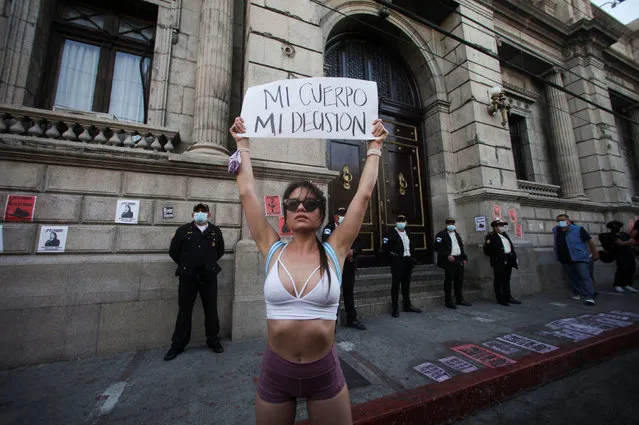 A demonstrator holds up a banner which reads “My body, my decision” during a protest against a law approved by Guatemala's Congress that punishes abortion with prison, prohibits same-sеx marriage and teaching about sеxual diversity in schools, outside the Congress building in Guatemala City, Guatemala on March 12, 2022. (Photo by Sandra Sebastian/Reuters)