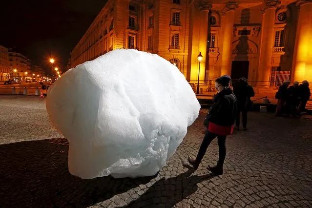 A woman looks at a mass of ice harvested from Greenland during an installation on Place du Pantheon for a project called Ice Watch Paris, in Paris, France, December 3, 2015. The World Climate Change Conference 2015 (COP21) continues at Le Bourget near the French capital. (Photo by Benoit Tessier/Reuters)