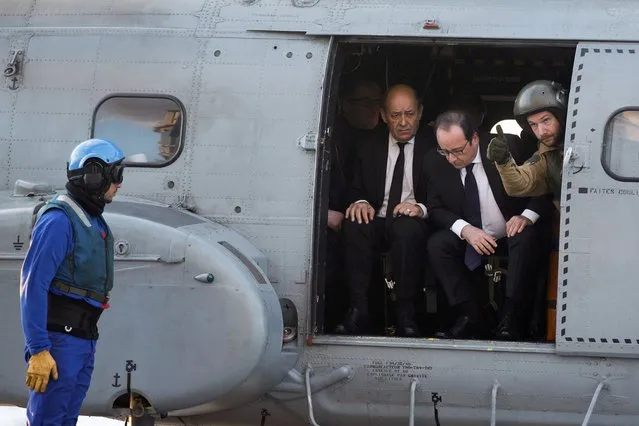French President Francois Hollande (C) and French Defence Minister Jean-Yves Le Drian (L) arrive by helicopter on the Charles de Gaulle aircraft carrier deployed in the Mediterranean Sea off the coast of Syria, December 4, 2015. (Photo by Reuters)