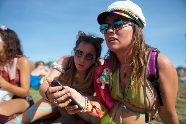 (L-R) Catie Gilbride, 21, and Lizzy  Huggler, 20, converse with friends on the third day of the Firefly Music Festival in Dover, Delaware U.S., June 16, 2018. (Photo by Mark Makela/Reuters)