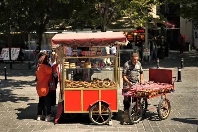 People buy 'simit', Turkey's ubiquitous pretzel-like snacks, at Eminonu commercial area in Istanbul, Turkey, Wednesday, June 7, 2023. Turkish President Recep Tayyip Erdogan won reelection last month despite a battered economy and a cost-of-living crisis that experts say are exacerbated by his unconventional economic policies. (Photo by Francisco Seco/AP Photo)