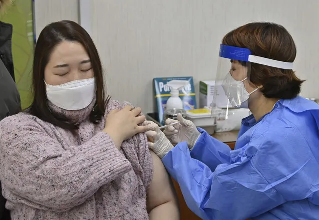 A nursing home worker, left,  receives the first dose of the AstraZeneca COVID-19 vaccine at a health care center in Seoul Friday, February 26, 2021. South Korea on Friday administered its first available shots of coronavirus vaccines to people at long-term care facilities, launching a mass immunization campaign that health authorities hope will restore some level of normalcy by the end of the year. (Photo by Jung Yeon-je /Pool Photo via AP Photo)