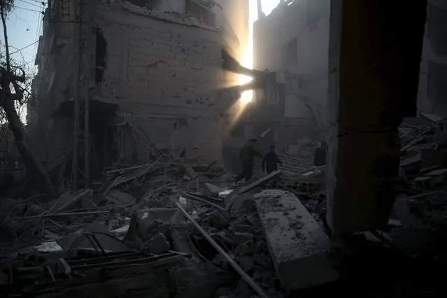 Residents inspect damage in a site hit by what activists said were airstrikes carried out by the Russian air force in the town of Douma, eastern Ghouta in Damascus, Syria January 10, 2016. (Photo by Bassam Khabieh/Reuters)