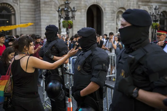 A protester argues as Catalan police officers clear up an independence protest camp set up outside the regional government in Saint Jaume square in Barcelona, Spain, Wednesday, September 26, 2018. (Photo by Emilio Morenatti/AP Photo)