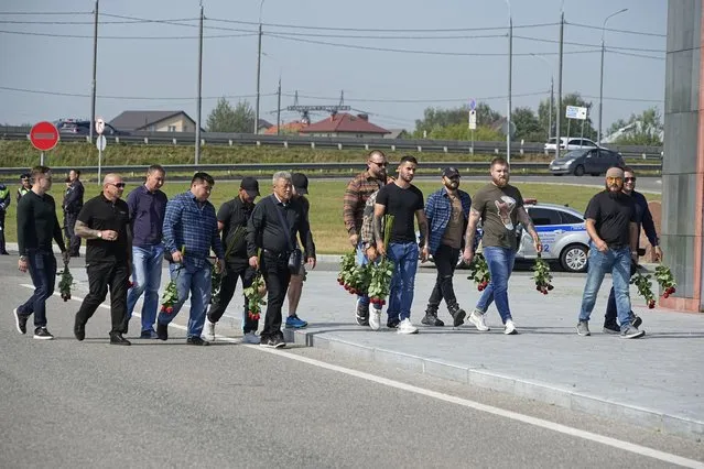 People walk to attend a farewell ceremony for Dmitry Utkin, who oversaw Wagner Group's military operations, at Federal Military Memorial Cemetery in Mytishchy, outside Moscow, Russia, Thursday, August 31, 2023. (Photo by Alexander Zemlianichenko/AP Photo)