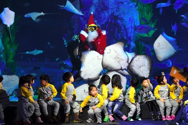 A South Korean diver wearing a Santa Claus outfit swims with fish in a tank during a Christmas event at the Lotte World Aquarium in Seoul on December 20, 2016. Christmas is one of the biggest holidays celebrated in South Korea with Christians forming over half the population. (Photo by Jung Yeon-Je/AFP Photo)