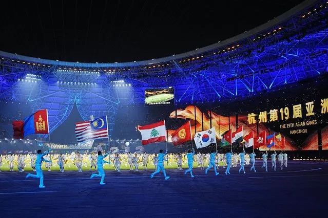Flags of the participating countries are carried during the closing ceremony of the 19th Asian Games in Hangzhou, China, Sunday, October 8, 2023. (Photo by Vincent Thian/AP Photo)