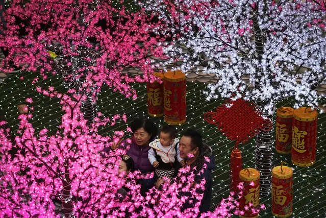 A Chinese family take a selfie in front of trees decorated with light installations for the upcoming Chinese Lunar New Year at a shopping mall in Beijing, Monday, February 1, 2016. Chinese will celebrate the Lunar New Year on Feb. 8 this year which marks the Year of Monkey on the Chinese zodiac. (Photo by Andy Wong/AP Photo)