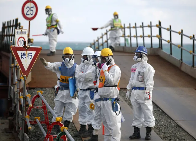 Workers, wearing protective suits and masks, are seen near the No. 3 and No.4 reactor buildings at Tokyo Electric Power Co's (TEPCO) tsunami-crippled Fukushima Daiichi nuclear power plant in Okuma town, Fukushima prefecture, Japan February 10, 2016. (Photo by Toru Hanai/Reuters)