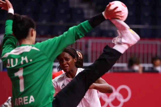 Juliana Machado of Angola looks on as Ju Hui of South Korea makes a save during the women's preliminary round group A handball match between South Korea and Angola of the Tokyo 2020 Olympic Games at the Yoyogi National Stadium in Tokyo on August 2, 2021. (Photo by Susana Vera/Reuters)