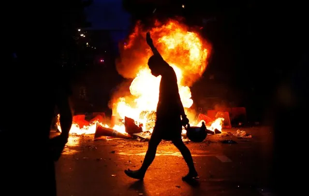 A demonstrator gestures during a protest against the government's handling of the coronavirus disease (COVID-19) pandemic, in Bangkok, Thailand, August 10, 2021. Police in Thailand fired tear gas, water cannon and rubber bullets to disperse protesters who took to the streets of Bangkok on Tuesday amid anger over the handling of the coronavirus pandemic by Prime Minister Prayuth Chan-ocha's government. (Photo by Soe Zeya Tun/Reuters)