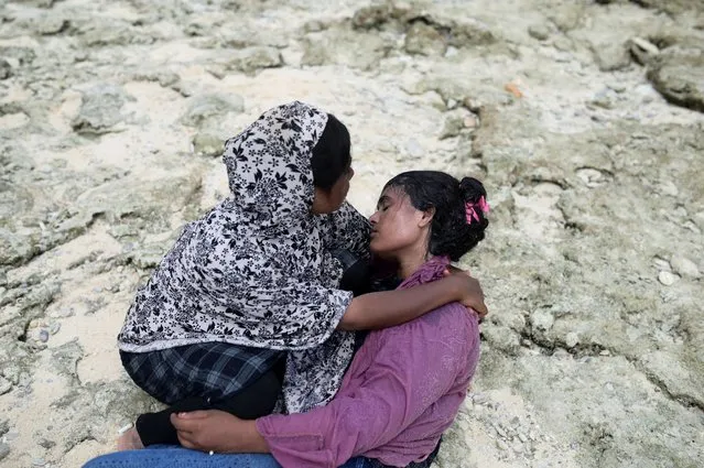 Rohingya Muslim women rest after landing on a beach in Sabang, Aceh province, Indonesia on November 22, 2023. (Photo by Riska Munawarah/Reuters)