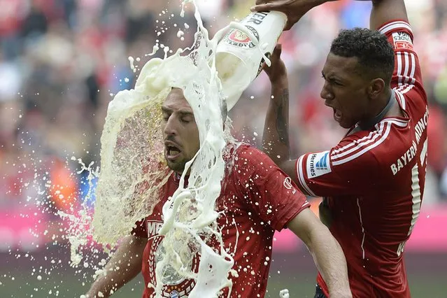 Bayern Munich's defender Jerome Boateng (R) pours beer on Bayern Munich's French midfielder Franck Ribery while celebrating their champion title, after winning 3:0 the German first division Bundesliga football match between Bayern Munich and FC Augsburg in Munich, southern Germany, on May 11, 2013. (Photo by Christof Stache/AFP Photo)