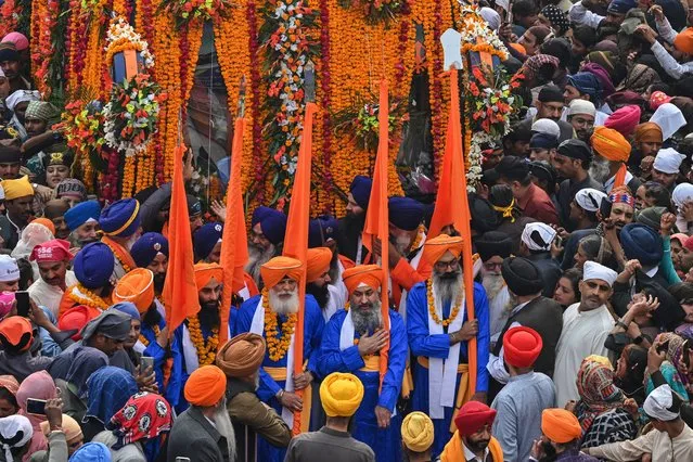 Sikh pilgrims take part in a ritual procession on the occasion of the birth anniversary of Guru Nanak Dev, the founder of Sikhism, in Nankana Sahib on November 27, 2023. (Photo by Arif Ali/AFP Photo)
