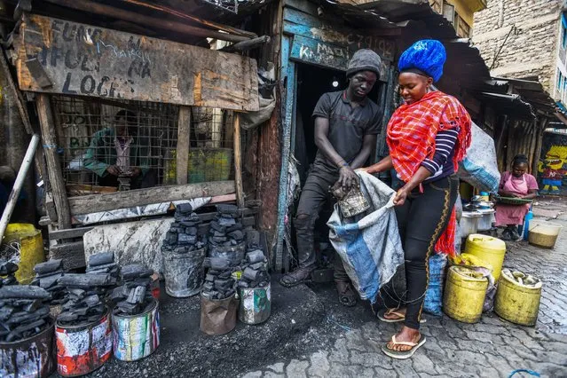 Residents of Mathare slum fill bags with coal in hard conditions in the capital of Kenya, Nairobi on November 06, 2023. The coal that workers produce with primitive methods by working overtime in unlicensed workshops is used for heating, cooking and other daily needs. (Photo by Gerald Anderson/Anadolu via Getty Images)