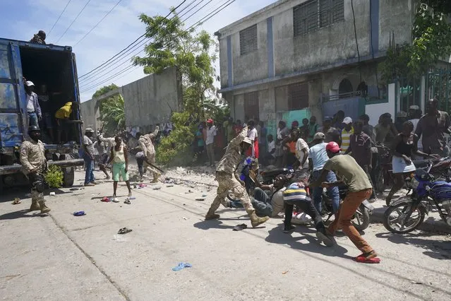 Police confront residents who temporarily overtook a truck loaded with relief supplies, in Les Cayes, Haiti, Friday, August 20, 2021. (Photo by Fernando Llano/AP Photo)