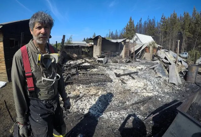 A firefighter stand next to burnt houses after a forest fire in the town of Nirivilo in the Maule region, Chile, January 25, 2017. (Photo by Nicolas Martinez/Reuters)