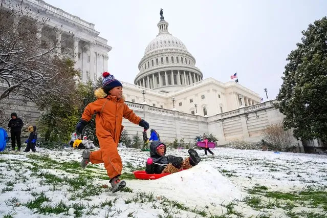 Children race each other down the sledding hill at the U.S. Capitol, as schools are closed due to a winter snowstorm, Tuesday, January 16, 2024 in Washington. (Photo by Jacquelyn Martin/AP Photo)