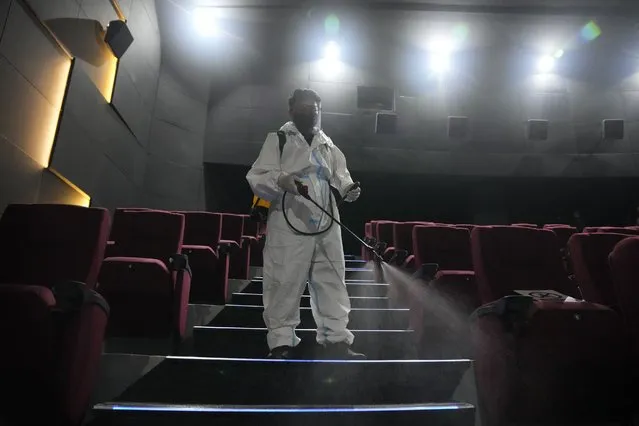 A worker in protective suit sanitizes a moviehouse as they prepare to reopen at the Eastwood mall in Quezon city, Philippines as government eases restrictions after a decline in Coronavirus cases in the country on Thursday, October 14, 2021. Several businesses were allowed to reopen in the next days as the country tries to revive the economy which have suffered due to the lockdowns to prevent the spread of COVID-19. (Photo by Aaron Favila/AP Photo)