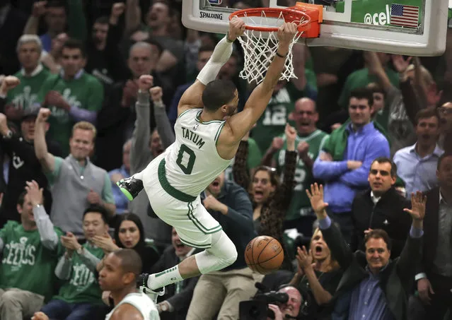 Boston Celtics forward Jayson Tatum (0) hangs on the rim after slamming a dunk against the Indiana Pacers in the final minute of the fourth quarter of Game 2 of an NBA basketball first-round playoff series, Wednesday, April 17, 2019, in Boston. The Celtics won 99-91. (Photo by Charles Krupa/AP Photo)