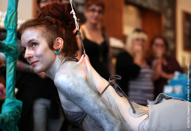 Alice Newstead inspects shark hooks that she had pierced into her skin during a demonstration against the shark fin trade