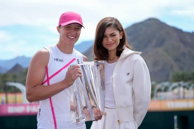 Iga Swiatek, of Poland, left, holds the trophy alongside actress Zendaya after defeating Maria Sakkari, of Greece, in the final match at the BNP Paribas Open tennis tournament, Sunday, March 17, 2024, in Indian Wells, Calif. (Photo by Ryan Sun/AP Photo)