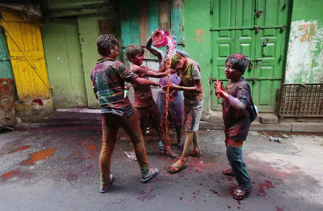 Boys pour coloured water on another boy during Holi celebrations in Kolkata, India, March 24, 2016. (Photo by Rupak De Chowdhuri/Reuters)