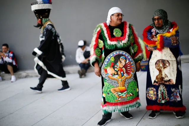 People in traditional costumes participate in a parade of Huehuenches and Chinelos, an indigenous nations dance, in Mexico City, Mexico on December 4, 2021. (Photo by Gustavo Graf/Reuters)