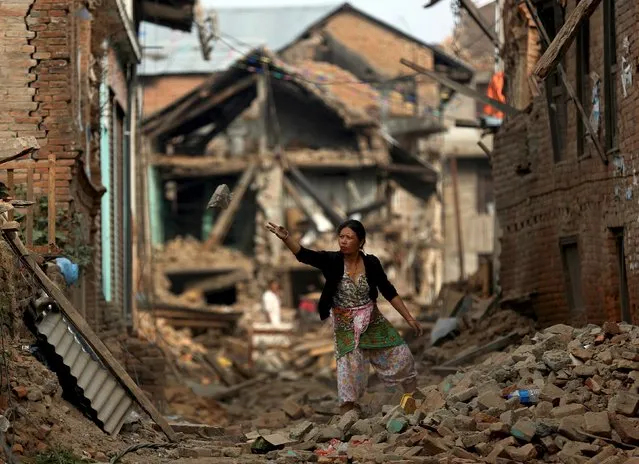 A woman works in front of her house on the outskirts of Kathmandu, Nepal, May 15, 2015. (Photo by Ahmad Masood/Reuters)