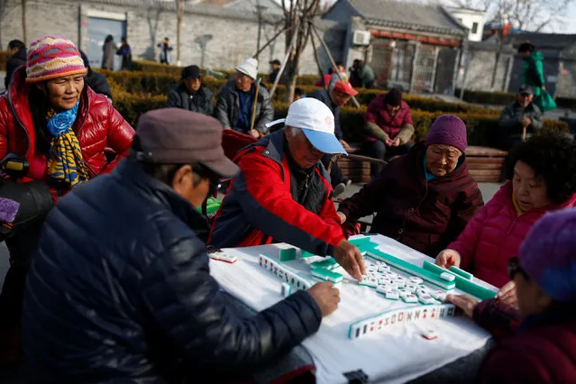 People play mahjong in a square in Beijing, China, February 25, 2017. (Photo by Thomas Peter/Reuters)