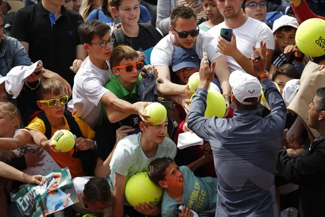 Spain's Rafael Nadal and his security guard right, ask fans to calm down to prevent children from getting crushed after Nadal's second round match of the French Open tennis tournament against Germany's Yannick Maden at the Roland Garros stadium in Paris, Wednesday, May 29, 2019. (Photo by Christophe Ena/AP Photo)